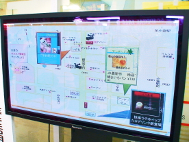 （写真）情報サイコロから発信された最新情報が、商店街に設置されたディスプレイに表示されている。
